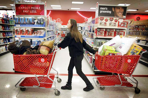 195964-a-woman-pulls-shopping-carts-through-the-aisle-of-a-target-store-on-th